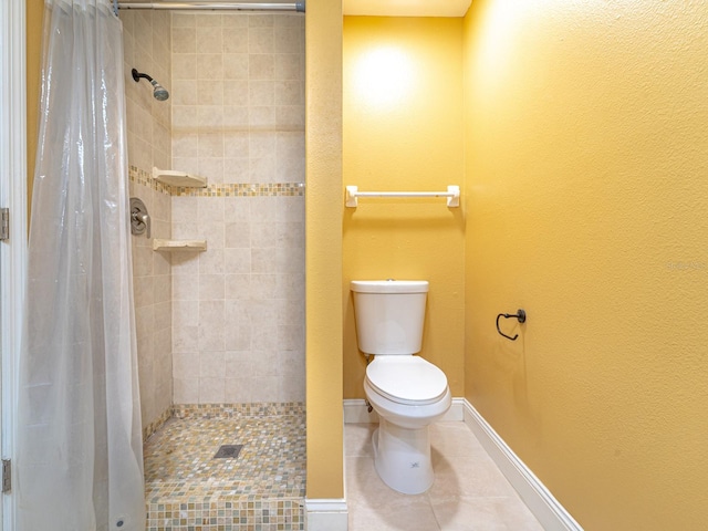 bathroom with a shower with curtain, toilet, and tile patterned floors