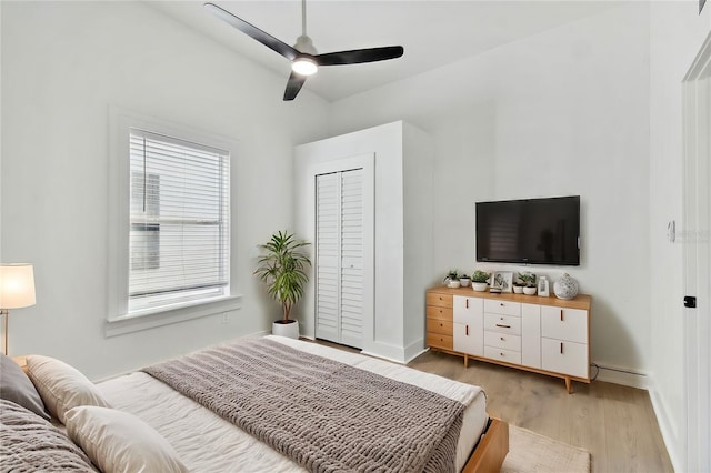 bedroom with light hardwood / wood-style flooring, a closet, and ceiling fan