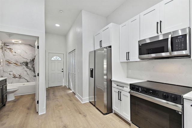 kitchen featuring white cabinetry, stainless steel appliances, and light wood-type flooring