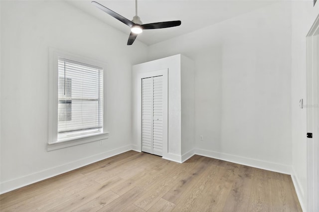 unfurnished bedroom with a closet, light hardwood / wood-style floors, and ceiling fan