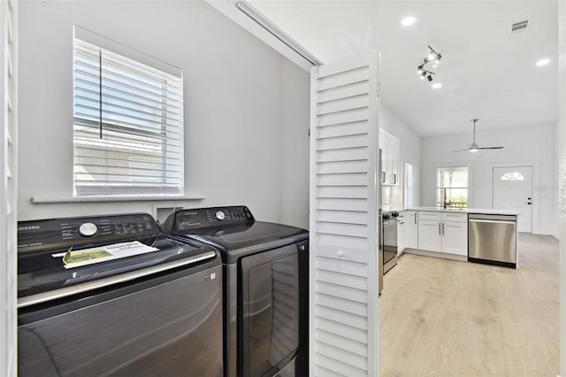 clothes washing area featuring ceiling fan, sink, separate washer and dryer, and light wood-type flooring