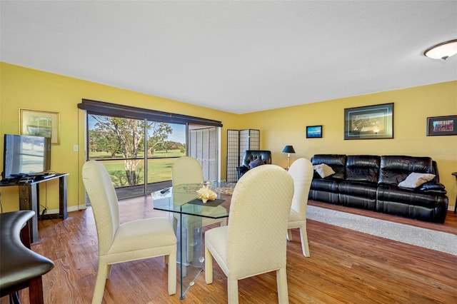 dining space with wood-type flooring