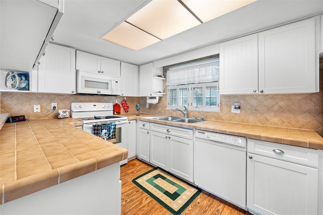 kitchen with sink, white cabinetry, and white appliances