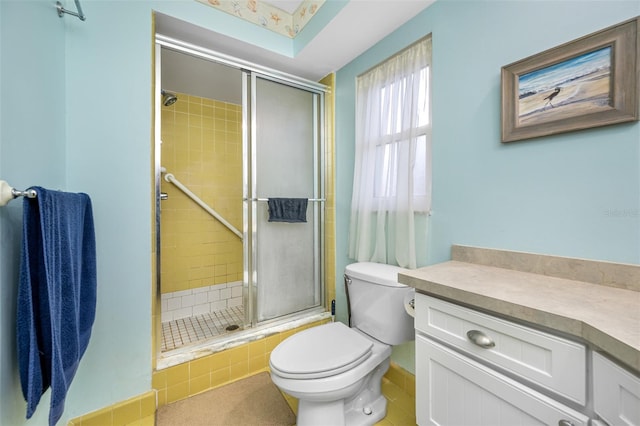 bathroom featuring a shower with door, vanity, toilet, and tile patterned floors