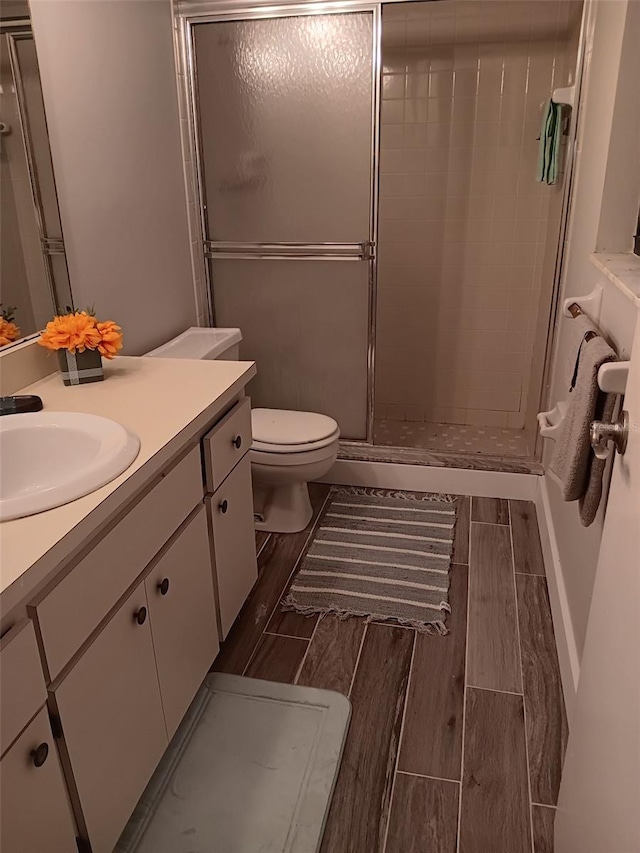 bathroom with vanity, toilet, and a shower with shower door