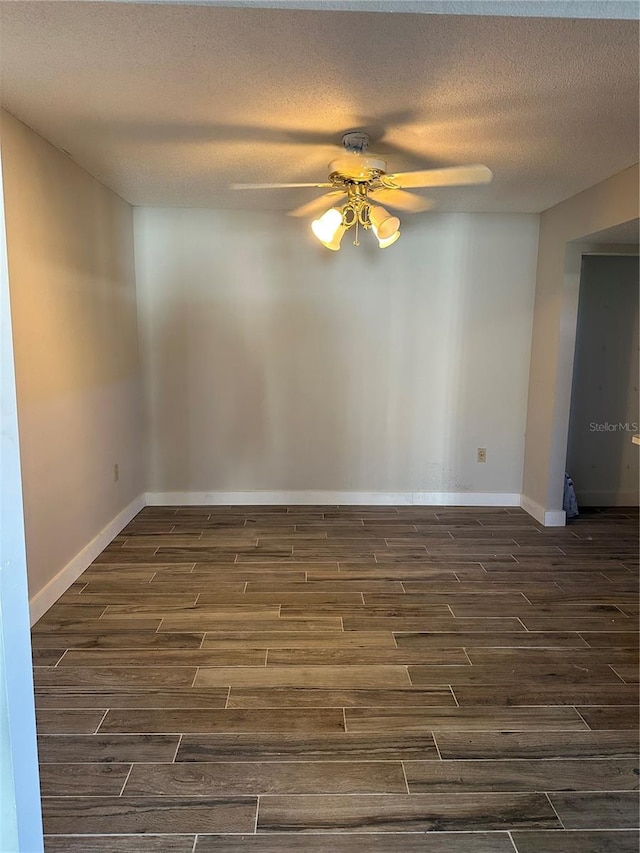 empty room with ceiling fan, a textured ceiling, and dark hardwood / wood-style flooring