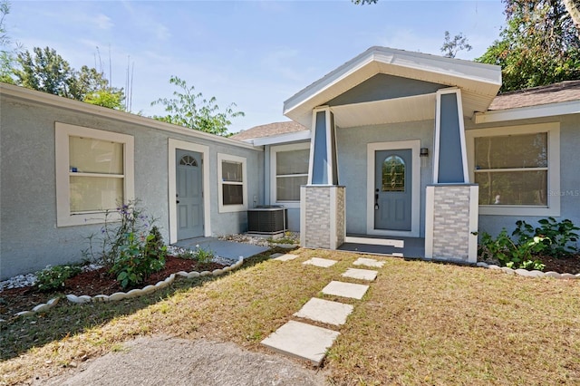 property entrance featuring central AC and a yard