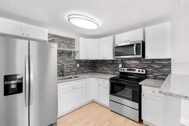 kitchen featuring sink, white cabinets, light hardwood / wood-style flooring, and stainless steel appliances