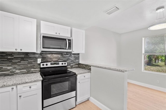 kitchen with decorative backsplash, kitchen peninsula, stainless steel appliances, white cabinetry, and light hardwood / wood-style floors