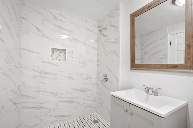 bathroom featuring vanity and tiled shower