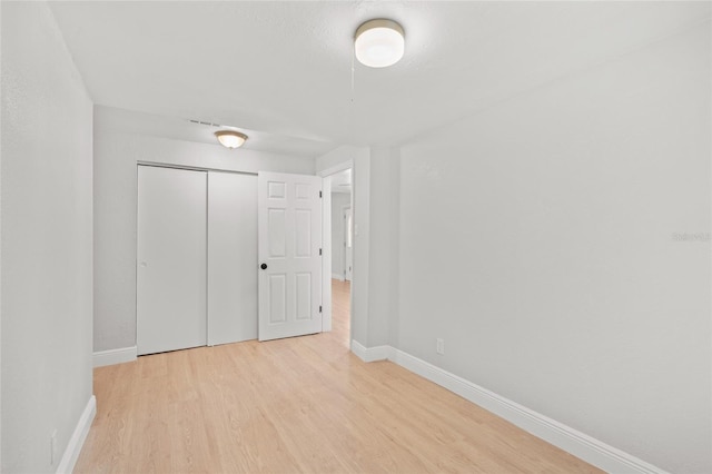 unfurnished bedroom featuring a closet and light wood-type flooring