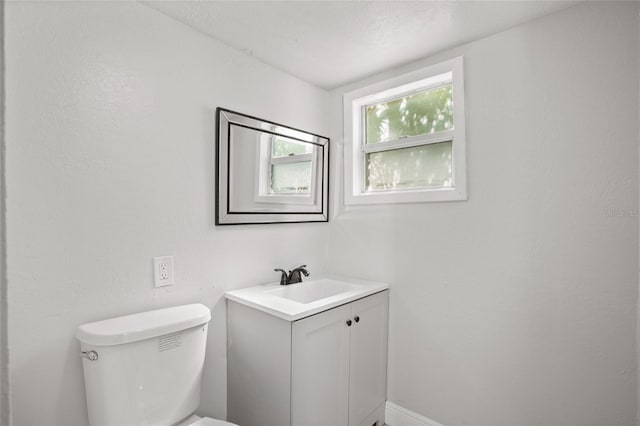 bathroom featuring toilet, a textured ceiling, and vanity