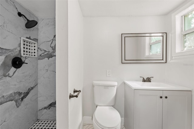 bathroom with vanity, tile patterned flooring, toilet, and tiled shower