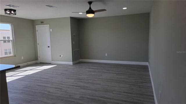 empty room with ceiling fan and dark hardwood / wood-style floors