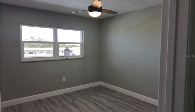 spare room with dark hardwood / wood-style floors, a textured ceiling, and ceiling fan