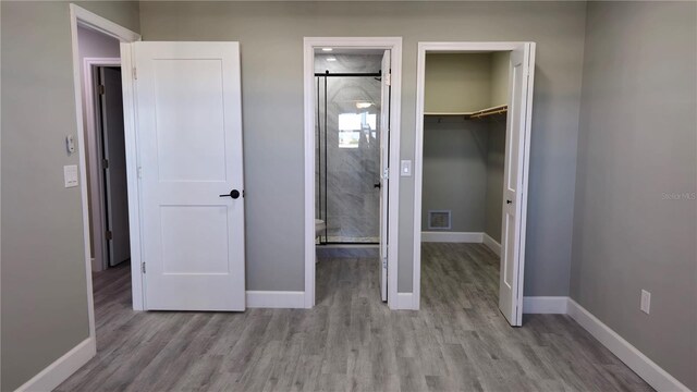 5623 80th St N Unit 510, Saint Petersburg, FL 33709 - unfurnished bedroom featuring a spacious closet, wood finished floors, baseboards, and a closet