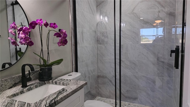 bathroom with toilet, vanity, and a shower with door