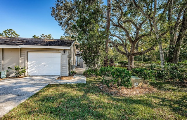 view of home's exterior featuring driveway, a yard, and a garage