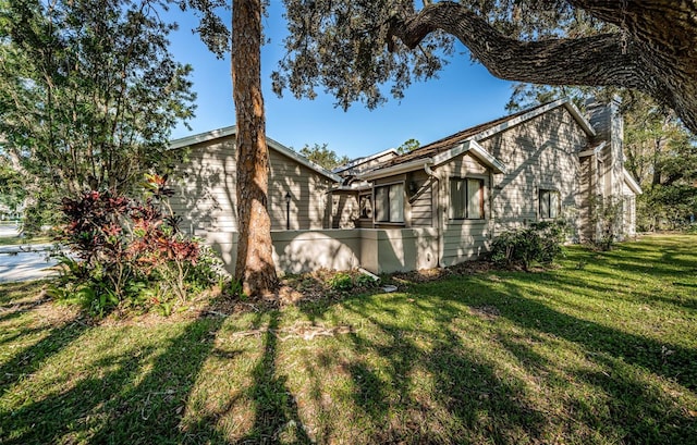 view of side of home with a yard