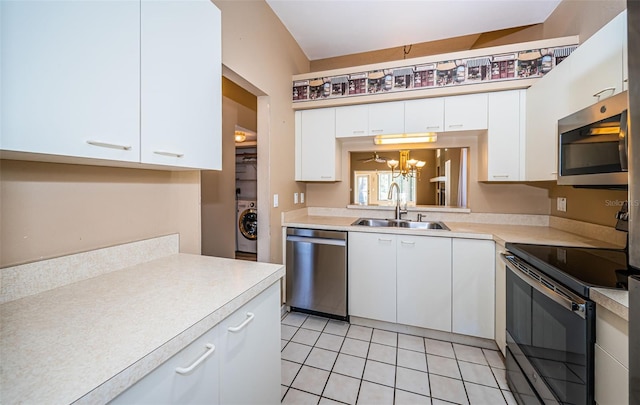 kitchen featuring washer / clothes dryer, light tile patterned floors, white cabinetry, sink, and stainless steel appliances