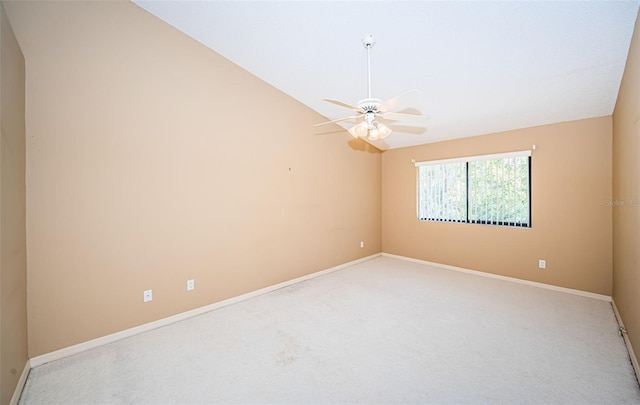 carpeted empty room featuring a ceiling fan, lofted ceiling, and baseboards