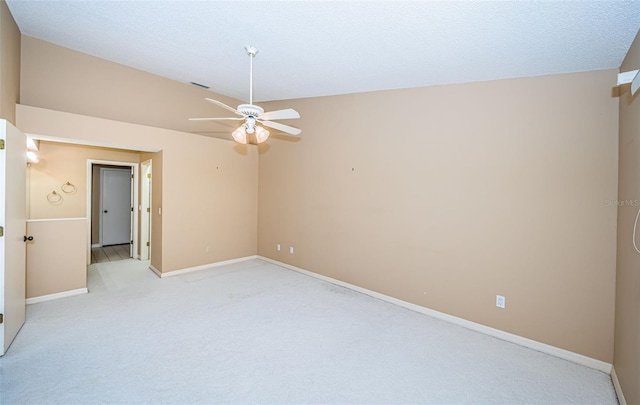 carpeted empty room featuring ceiling fan and a textured ceiling