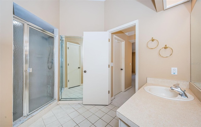 bathroom with vanity, a skylight, a shower with shower door, and tile patterned flooring