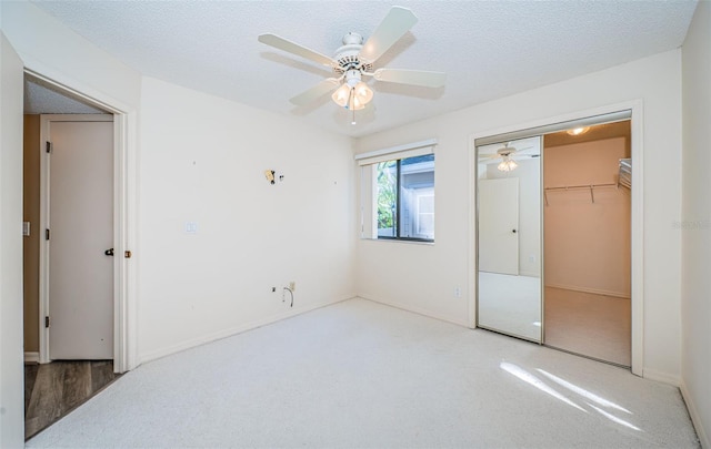 carpeted bedroom with a textured ceiling, a closet, and ceiling fan