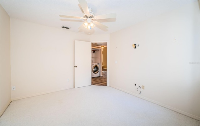 unfurnished room featuring washer / dryer, carpet flooring, and ceiling fan