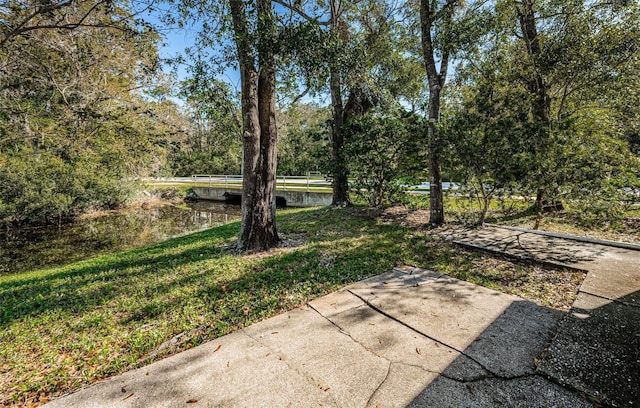 view of yard featuring a water view and a patio area