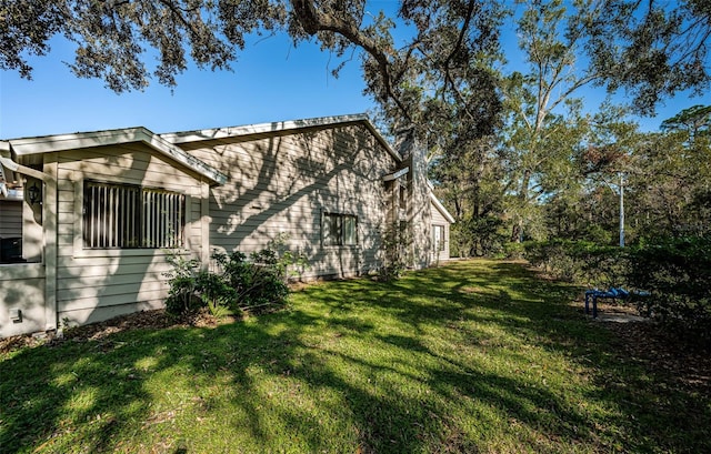 view of side of home with a yard