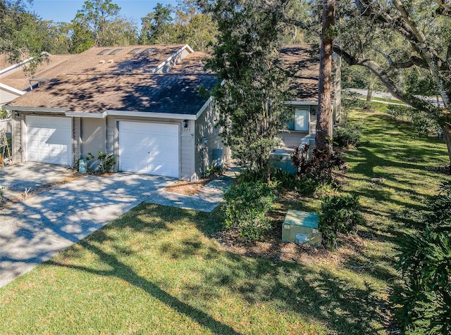 view of front of home with a front yard, driveway, a garage, and a shingled roof