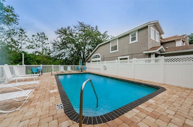 community pool featuring fence and a patio area