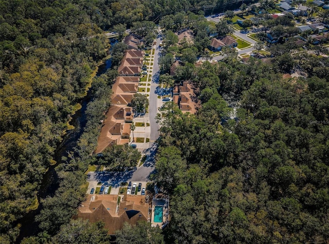 drone / aerial view featuring a residential view and a view of trees