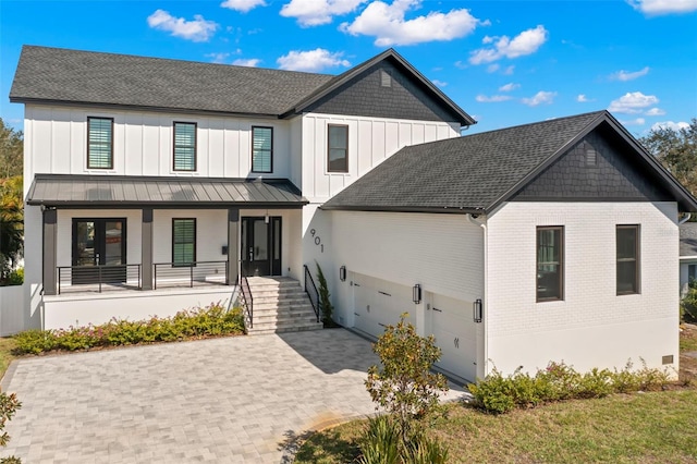 modern inspired farmhouse featuring a garage and a porch