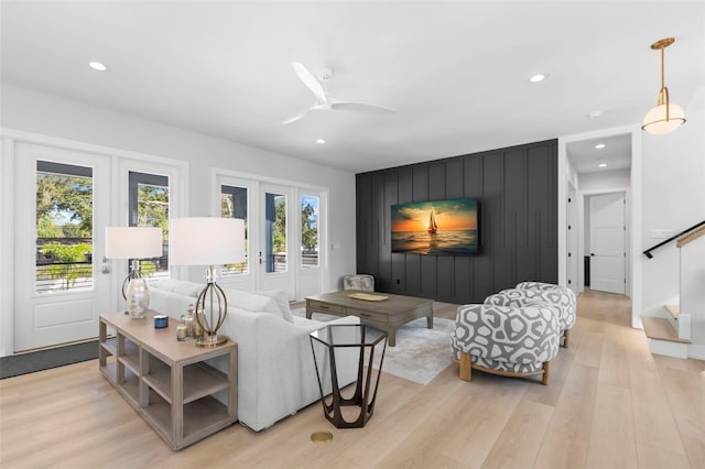 living room with light hardwood / wood-style flooring and ceiling fan