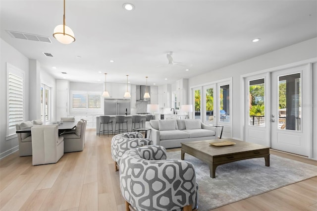 living room featuring light wood-type flooring and ceiling fan