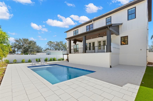 rear view of house featuring a patio area, a fenced in pool, and ceiling fan