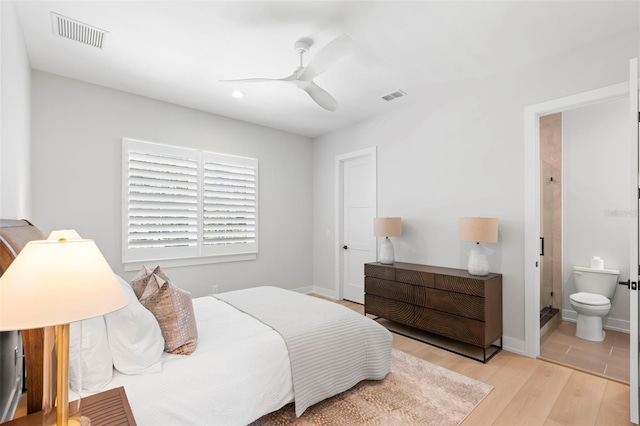 bedroom with ceiling fan, ensuite bathroom, and light wood-type flooring