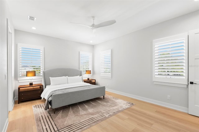 bedroom with light hardwood / wood-style floors, multiple windows, and ceiling fan