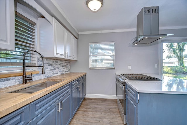 kitchen with island range hood, white cabinetry, and a wealth of natural light