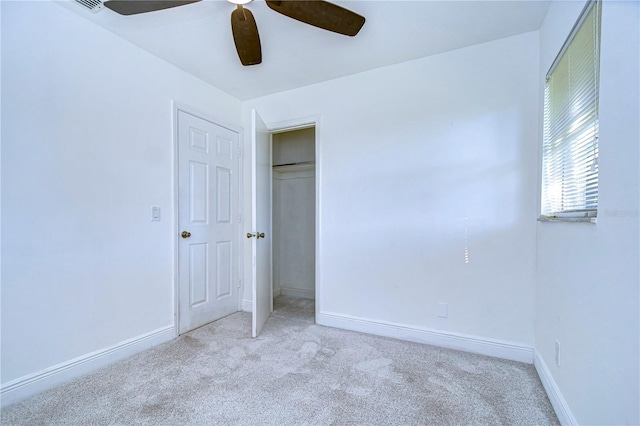 unfurnished bedroom featuring light colored carpet, ceiling fan, and a closet