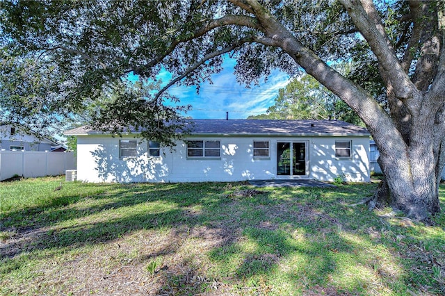 rear view of house featuring central AC and a yard