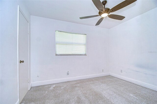 empty room featuring ceiling fan and light carpet