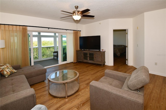 living room featuring hardwood / wood-style floors, a textured ceiling, and ceiling fan