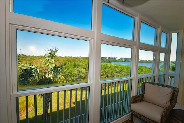 sunroom / solarium featuring a water view