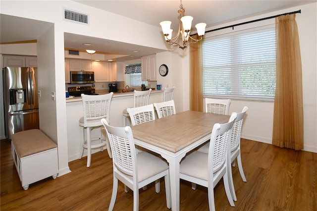 dining room with an inviting chandelier and dark hardwood / wood-style flooring