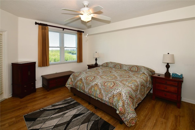 bedroom with dark wood-type flooring and ceiling fan