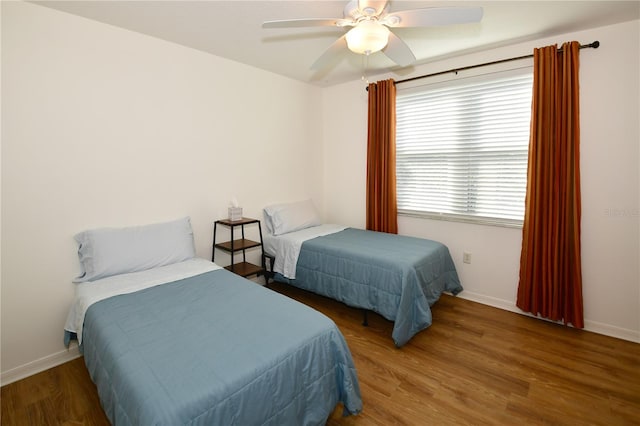 bedroom with dark hardwood / wood-style floors and ceiling fan