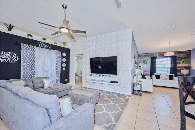 living room featuring lofted ceiling, ceiling fan, and light tile patterned floors